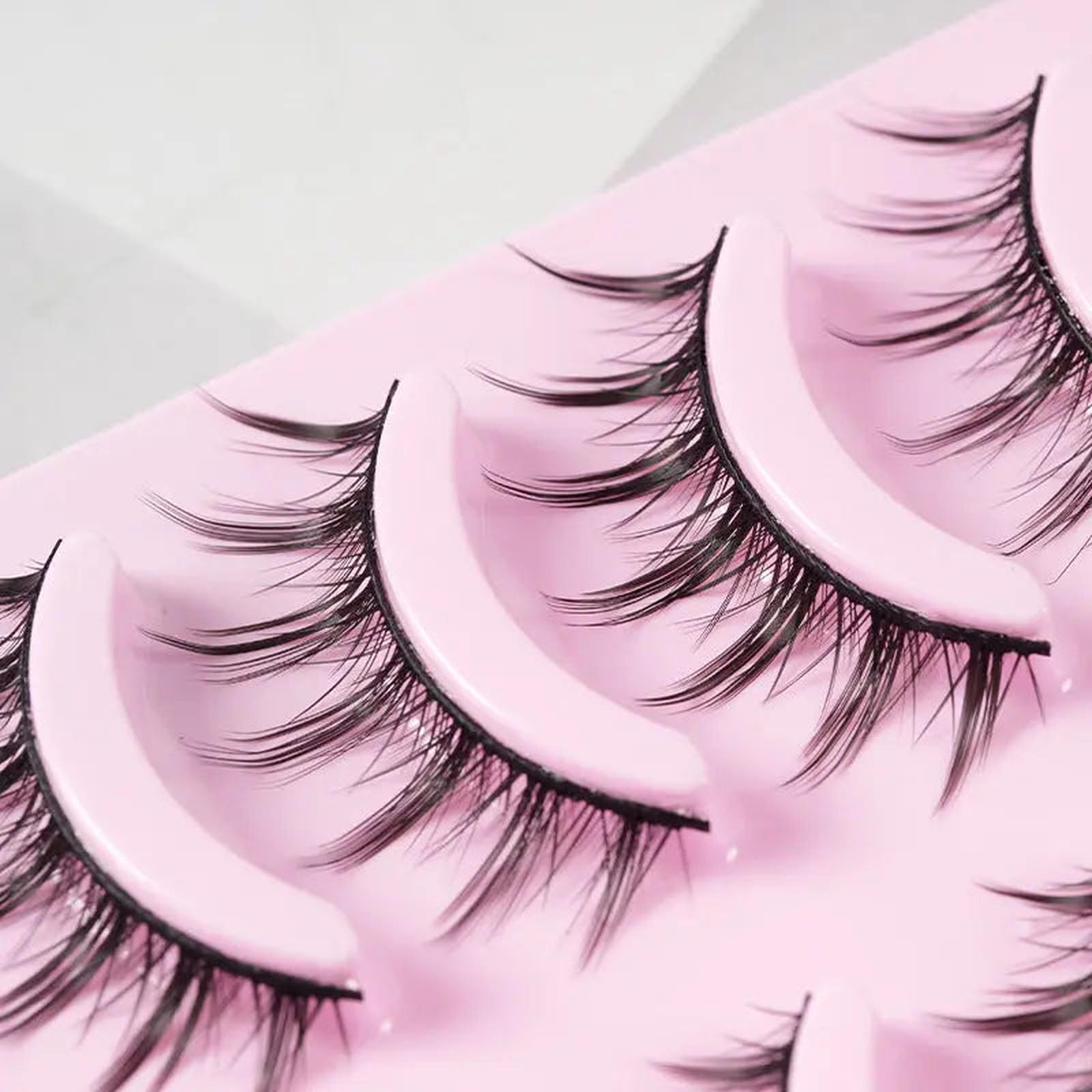 Five pairs of trendy manga-style false eyelashes from Trendsi, featuring natural, wispy design for anime cosplay and Korean makeup looks.