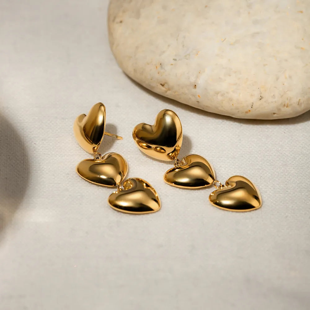 Gold stainless steel heart earrings, trendy jewelry by Trendsi, featuring a stylish and modern heart-shaped design.