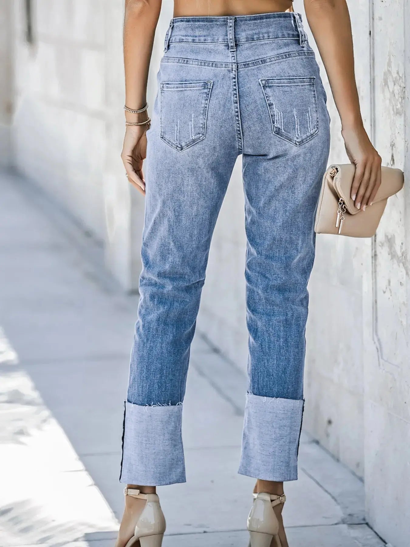 Light blue high waist distressed straight leg jeans from Trendsi, featuring a fitted waist and casual ripped details.
