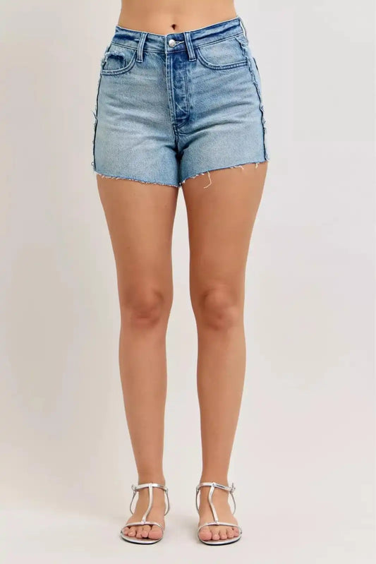 Judy Blue HW Rigid Magic Cut Off Denim Shorts with raw side seams, featuring distressed details and a high-waisted fit.