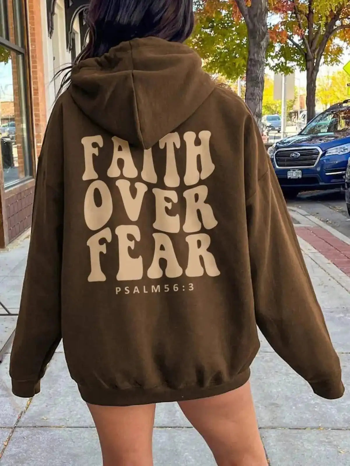 Pink dropped shoulder hoodie with "Faith Over Fear" graphic, casual fit, Trendi brand, comfortable and stylish for everyday wear.